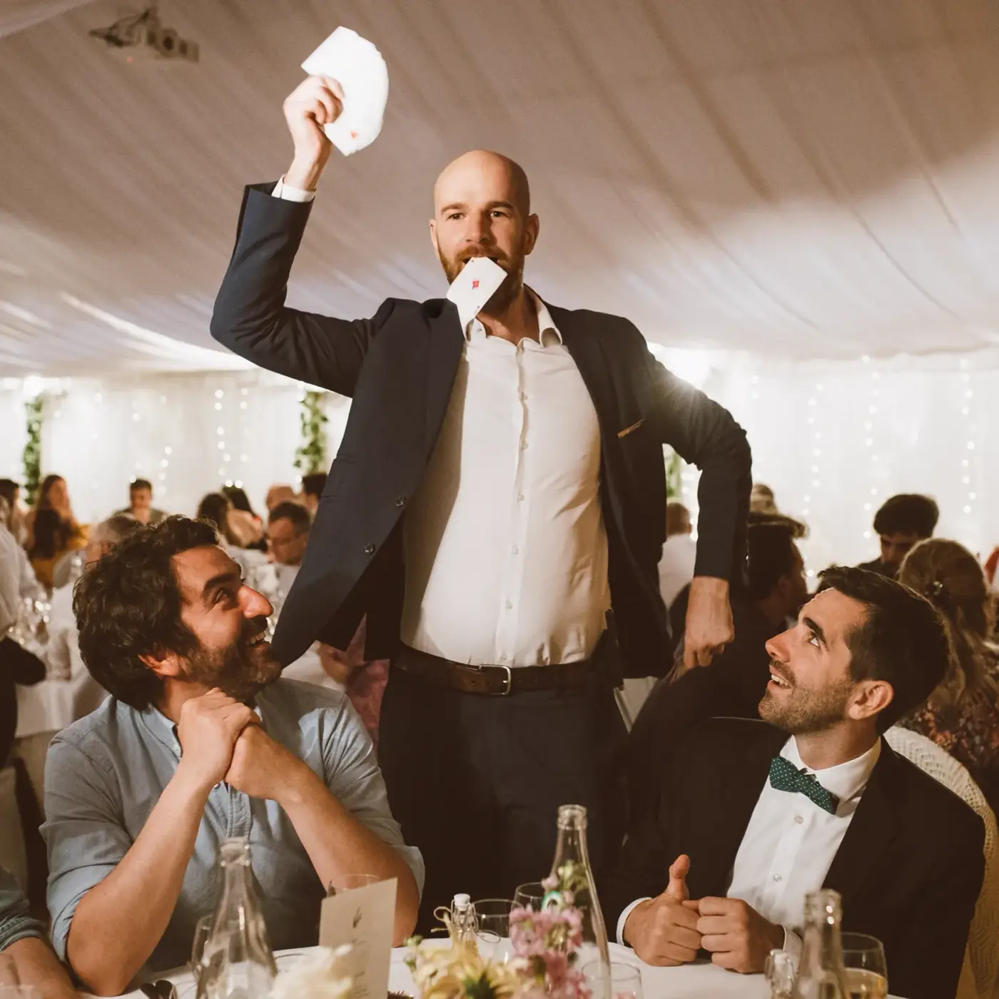 Invités attablés réagissant à un tour de magie pendant un dîner